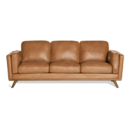 Discover the Maddox Sofa: a brown leather sofa with plush cushions for top comfort. Its sleek mid-century modern design, angled armrests, and wooden legs make it stand out elegantly against a plain white background.