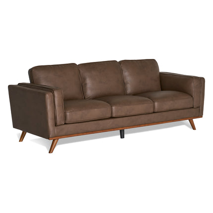 The Maddox Sofa, a brown leather piece, features plush cushions and angled wooden legs. Its clean, modern lines capture the essence of mid-century modern style, making it ideal for any contemporary living space.