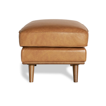 The Maddox Ottoman features a tan leather rectangular cushion and four wooden legs, adding mid-century charm to any living space, elegantly set against a plain white background.
