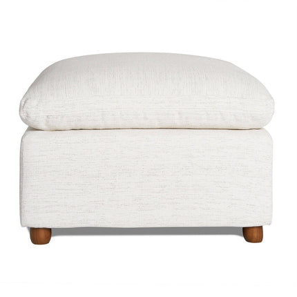 The My Cloud Slope 30 Ottoman features a cream color with a cushioned, textured top and wooden legs. Its simple, modern design offers customizable comfort, perfect for a living room or lounge area.