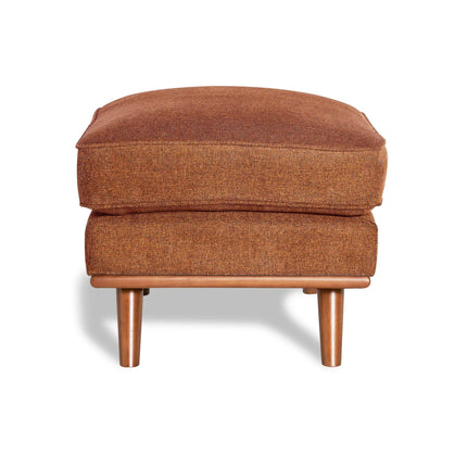 The Maddox Ottoman features brown upholstery and a rectangular cushion, gracefully sitting on wooden legs to bring mid-century charm and a soft shadow to your living space.