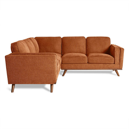 Discover the Maddox Sectional: a stylish brown L-shaped sofa ideal for any living room. Featuring plush cushions, wooden legs, and a mid-century modern design with smooth, textured fabric, it offers exceptional comfort on a plain white background.
