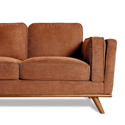 The Maddox Sectional, with its mid-century modern style, features brown upholstery, cushioned seats, angled wooden legs, and a right-side armrest. These elements elevate any living room space. The image highlights the elegant sofas right half.
