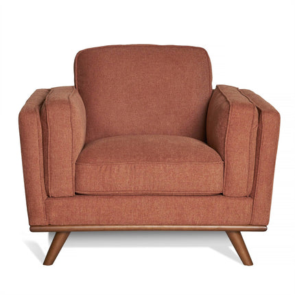 Meet the Maddox Chair: a mid-century modern armchair featuring plush, rust-colored fabric upholstery. It offers thick armrests, a square backrest, and a padded seat. Elegant angled wooden legs perfectly complement the Maddox Sofa Set.