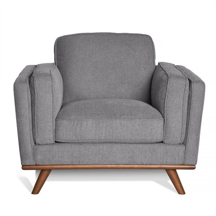 The Maddox Chair is a modern gray armchair with a sleek design, plush cushions for comfort, and outward-angled wooden legs that add a mid-century modern touch.