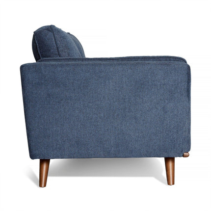 A side view of the Maddox Sofa reveals its mid-century modern allure with blue upholstery and wooden legs. It features plush cushions, a simplistic design, smooth fabric, and a slightly reclined back for comfort. The tapered, polished wooden legs add a classic touch.