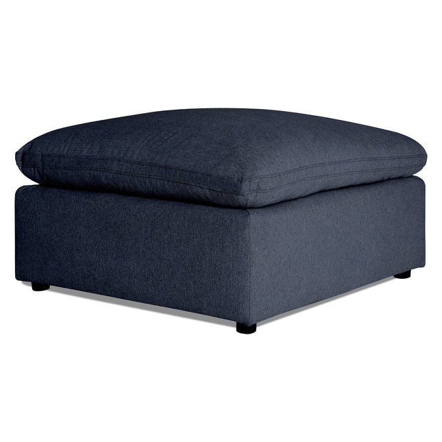 A dark gray My Cloud 40 Ottoman, with a large cushioned top and low-profile legs, sits elegantly on a plain white background, showcasing the art of comfort and customizable options.