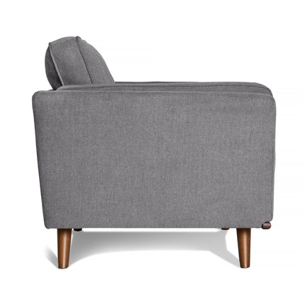 Side view of the Maddox Chair, featuring grey upholstery and wooden legs. The chair offers plush cushions, a cushioned backrest, and sleek armrests. Its modern, minimalist design complements a contemporary living room perfectly.